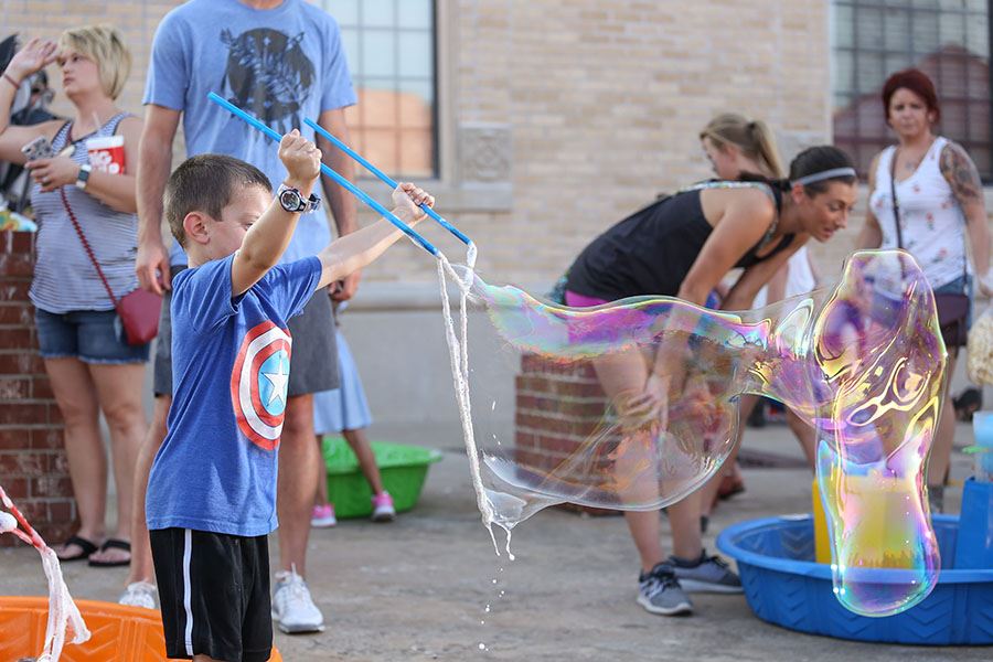 Kid Making a Huge Bubble with a Special Tool