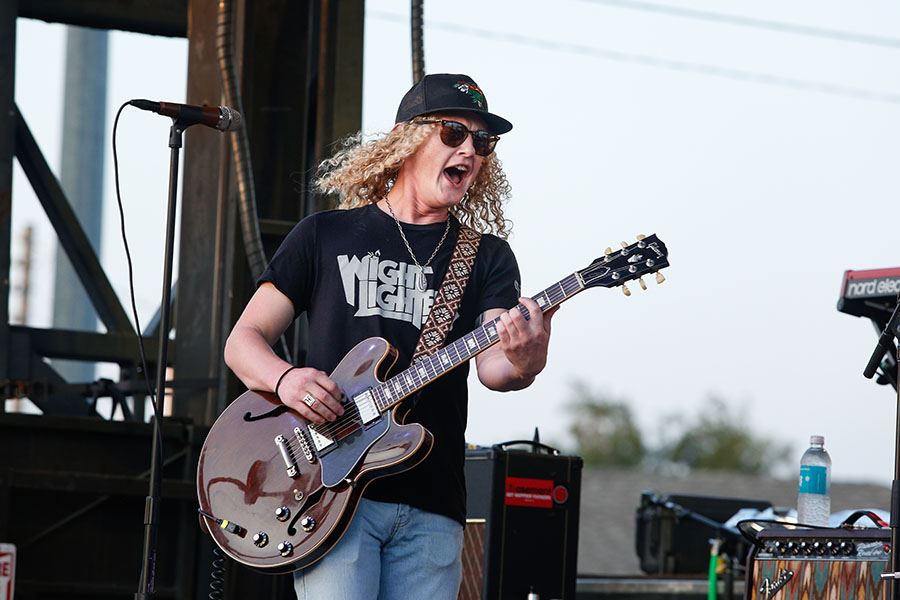 Man in Sunglasses Playing Guitar on Stage