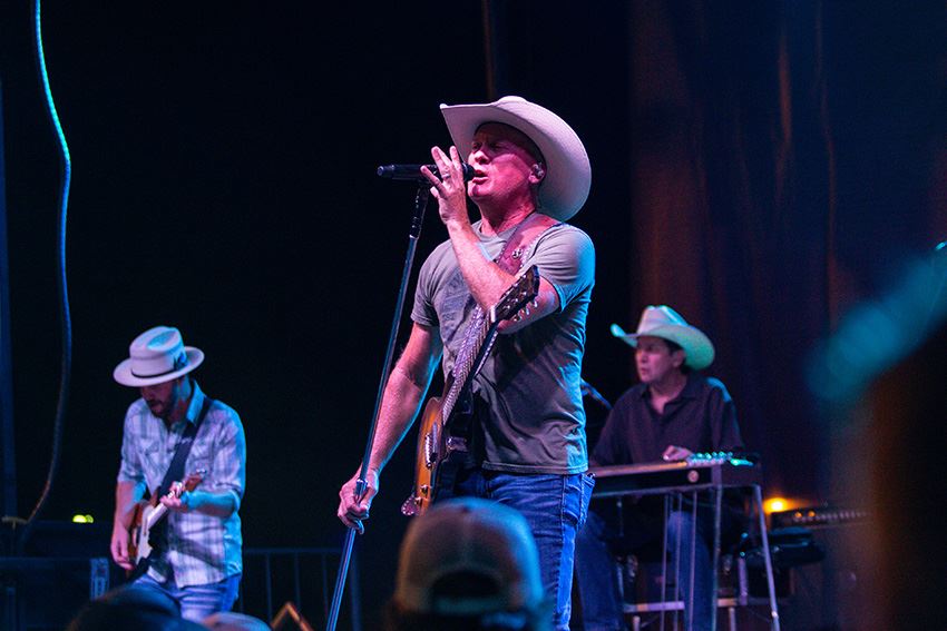 Man in a Cowboy Hat Singing Soulfully Into the Microphone